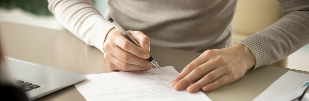 A woman signing some paperwork